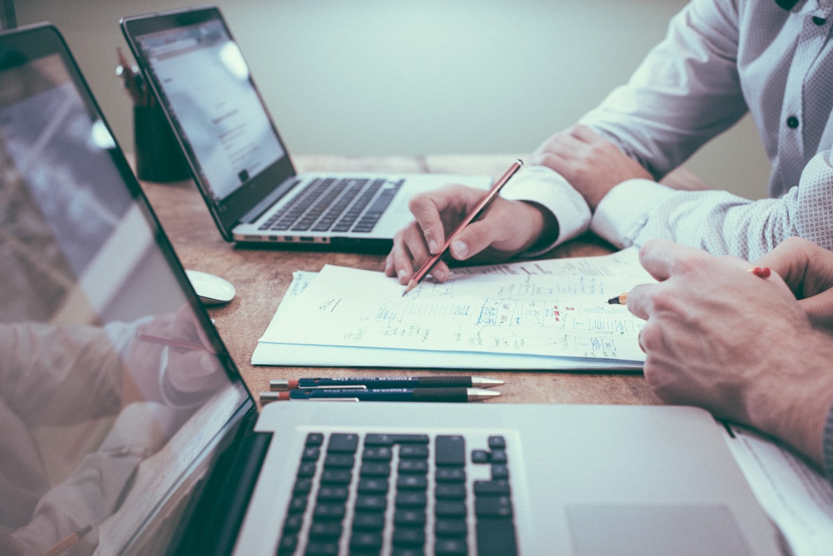 Advisor reviewing retirement cash-flow notes with a client at a meeting table